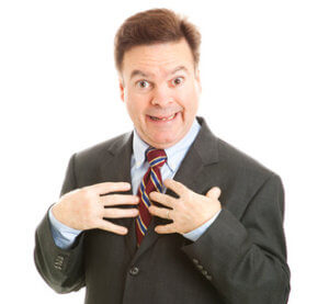 Narcissist looking surprised and pointing to himself as if to say "who me?" Isolated on white.